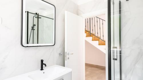 a white bathroom with a sink and a mirror at Villa Julija by Villas Guide in Smokvica