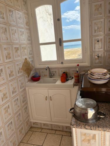 a kitchen with a sink and a window at Cosy Apparemment in Nabeul