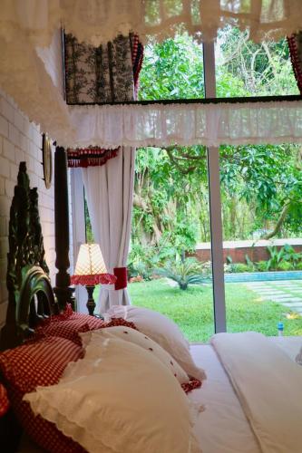 a bedroom with a bed with a window at Big Pvt Pool & Garden 3BHK Villa, Morjim Beach 10-14mts in Siolim