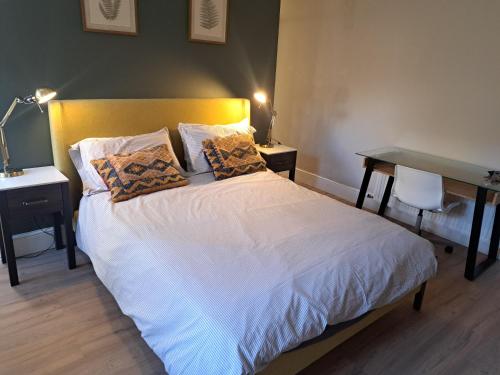 a bedroom with a white bed with two pillows at Two bed Seaside retreat in Dublin