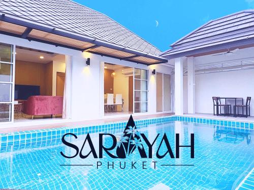 a swimming pool in front of a house at Sarayah Phuket Pool Villa in Phuket
