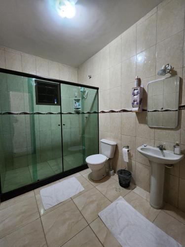 a bathroom with a shower and a toilet and a sink at Espaço Sunshine in Saquarema