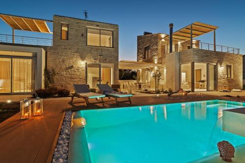 a house with a swimming pool in front of a house at Annassa Experience Villa 2' walk from Almyrida beach in Almyrida