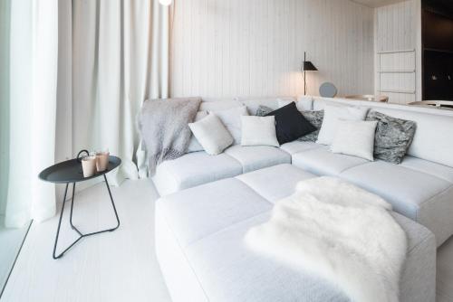 a white living room with a white couch and a table at Arctic TreeHouse Hotel in Rovaniemi