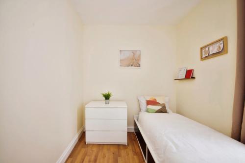 a small bedroom with two beds and a dresser at The Green Garden House near Tottenham Stadium Alexandra Palace Finsbury P in London
