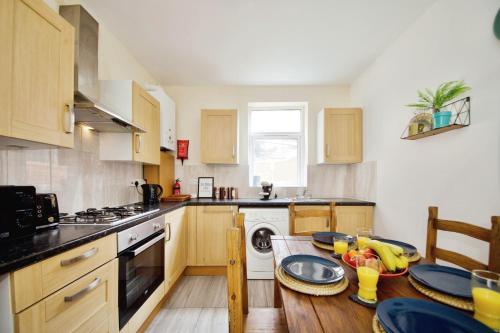a kitchen with wooden cabinets and a table with plates on it at The Green Garden House near Tottenham Stadium Alexandra Palace Finsbury P in London