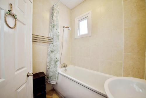 a bathroom with a white tub and a sink at The Green Garden House near Tottenham Stadium Alexandra Palace Finsbury P in London