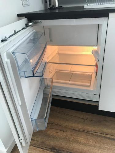 an empty refrigerator with its door open in a kitchen at An apartment overlooking the harbor Kolding fjord in Kolding