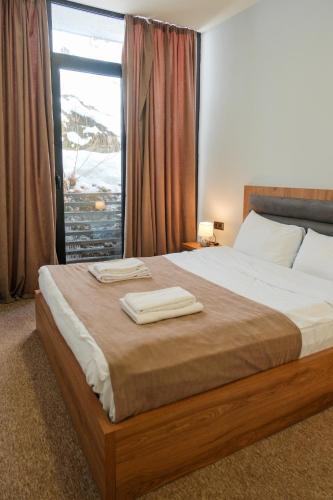 a bedroom with a bed with two towels on it at LALO Hotel Abastumani in Abastumani