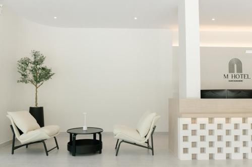 a living room with two chairs and a table at M Hotel Kanchanaburi in Ban Chuk Kum