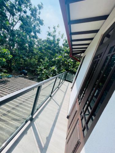 an open door on a house with a balcony at Woori House in Kamburugamuwa