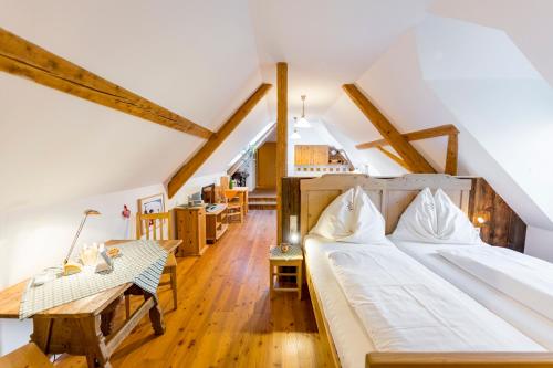 a bedroom with two beds and a table in a attic at Buchgrabenhof in Windisch Minihof