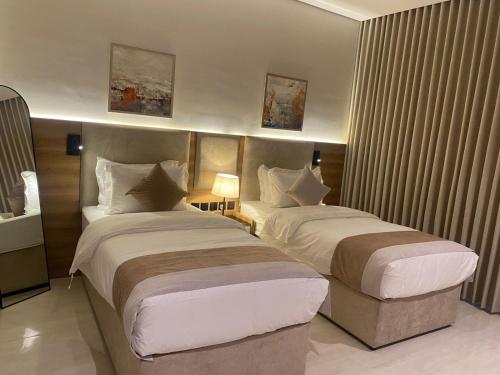 a hotel room with two beds in a room at Albateel 2 Serviced Apartments-اقتصادي in Riyadh