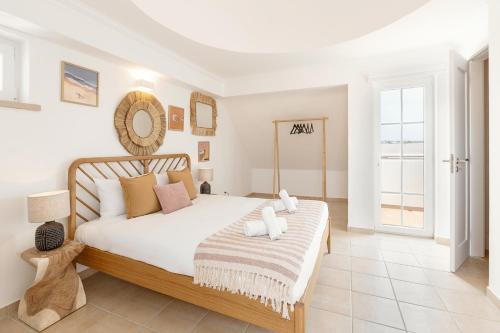 a bedroom with a large white bed with pillows at Casa da Shaka Baleal in Ferrel