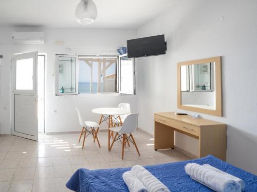 a bedroom with a bed and a desk and a table at Votsalo in Kardamaina