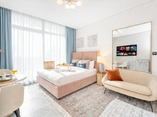a bedroom with a bed and a couch and a chair at Peninsula One Suites by Prestige Nest in Dubai