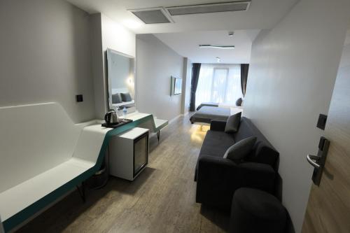 a living room with a couch and a tv in a room at Midis Otel in Edirne
