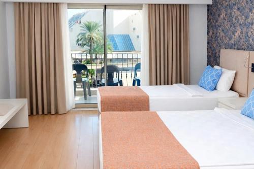 a hotel room with two beds and a balcony at Alder Garden Resort -Ultra All Inclusive in Kemer