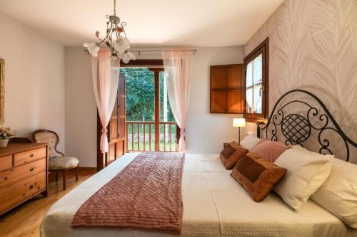 a bedroom with a large bed and a window at Casa cerca Playa Cuevas del Mar Llanes - River in Llanes