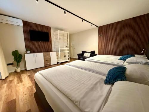 a bedroom with two beds and a flat screen tv at Boutique hotel ZBILJE in Zbilje