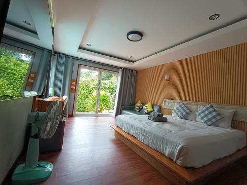 a bedroom with a large bed and a large window at Anita dream house in Khao Sok National Park