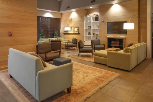 a lobby with couches and chairs and a television at GreenTree Inn & Suites Phoenix Sky Harbor in Phoenix