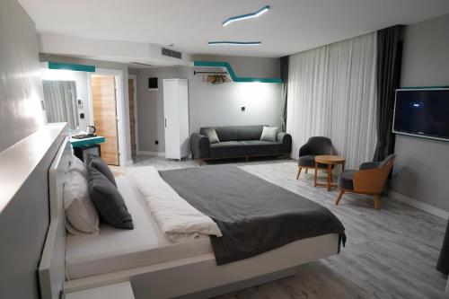 a bedroom with a large bed and a living room at Midis Otel in Edirne