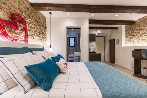 a bedroom with a large white bed with blue pillows at Arco di Pietra B&B in Crotone