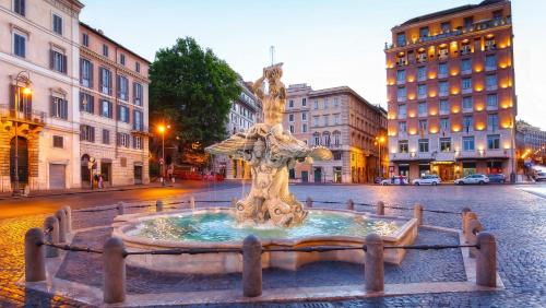 a fountain in the middle of a street with buildings at Parisii Luxury Relais Rome-Fontana di Trevi in Rome