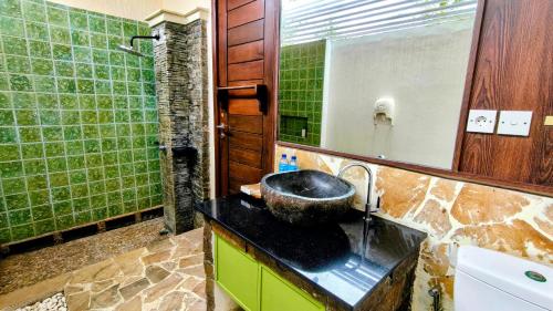 a bathroom with a sink and a mirror at The Trawangan Resort in Gili Trawangan