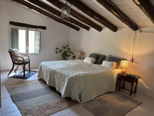 a bedroom with a large bed and a chair at casa mushin in Useras