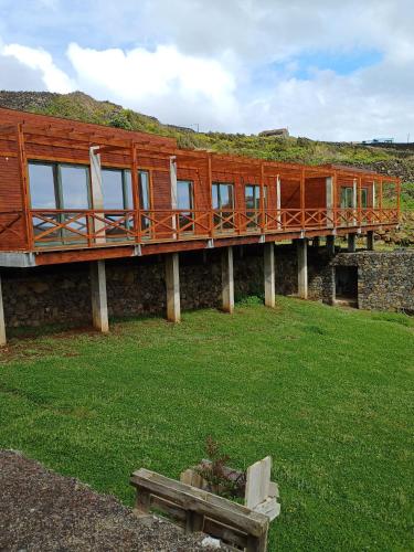 a building with a deck on top of a grass field at Salga Lodge in Angra do Heroísmo