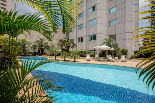 a large swimming pool in front of a building at Intercity São Paulo Ibirapuera in São Paulo
