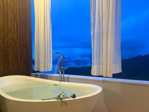a bath tub in a bathroom with a window at ไร่ชาอาโซ -ที่พักดอยช้าง in Ban Huai Khai