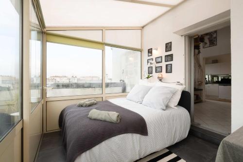 a bedroom with a large bed and a large window at Loft Duplex Terrasse View on Paris in Paris