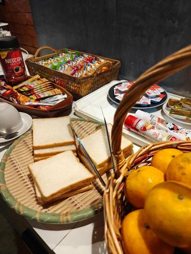 a table with a plate of bread and a basket of fruit at Phangnga Keeree Resort & Gallery in Phang-nga