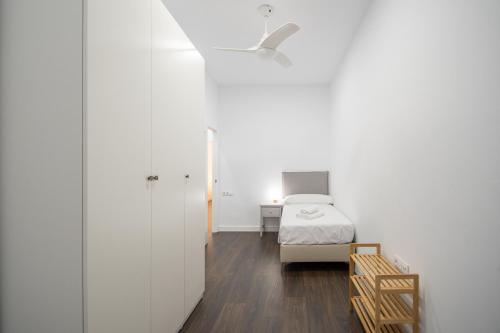 a white bedroom with a bed and a desk at Zambra en Cádiz in Cádiz