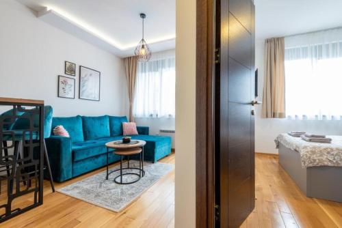 a living room with a blue couch and a table at Zlatibor 2 in Zlatibor