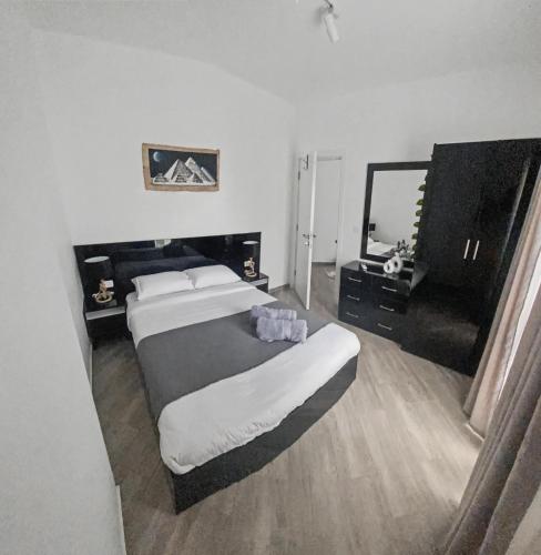 a bedroom with a large bed and a mirror at 3BR 2BA Retreat with Four Pools Gym and Onsite Dining Close to El Gouna in Hurghada
