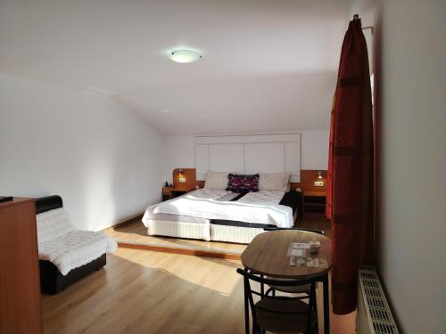 a bedroom with a bed and a table and a chair at Guest House Lila in Bansko