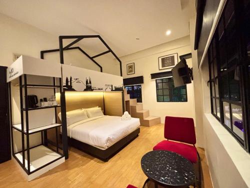 a small bedroom with a bed and a chair at Star Mews Hotel Changkat Bukit Bintang in Kuala Lumpur
