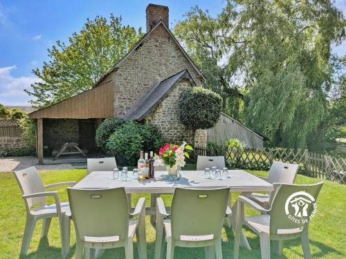 a white table and chairs in a yard at La grande reignière in Brécé