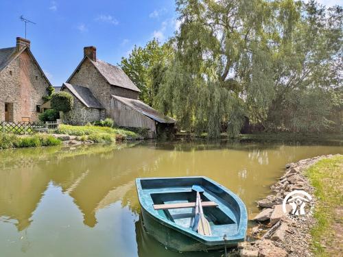 a blue boat sitting in the water in front of buildings at La grande reignière in Brécé