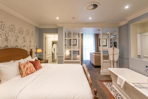 a bedroom with a large bed and a bath tub at King Street Townhouse Hotel & Spa in Manchester