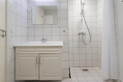 a white bathroom with a sink and a shower at Faxe Ladeplads Motel in Hylleholt