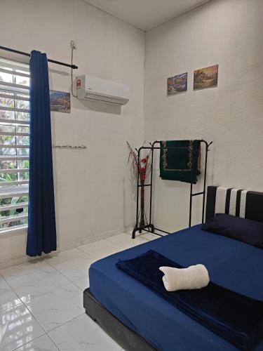 a bedroom with a blue bed and a fan at Penarik baru homestay in Kampung Penarik