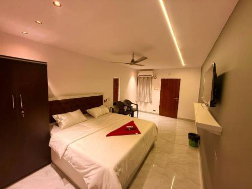 a bedroom with a bed with a red napkin on it at Capital Stay Inn in Vijayawāda