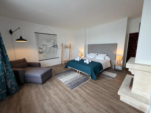 a bedroom with a bed and a couch and a chair at Côté Port in Granville