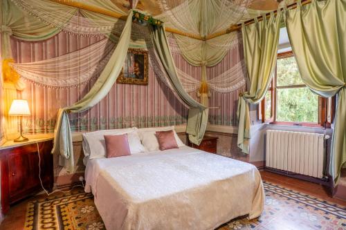 a bedroom with a bed in a room with curtains at Palazzo Tombesi Trecci in Montepulciano