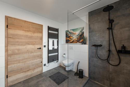 a bathroom with a shower and a toilet and a glass door at BPS Apartment#2 Comfort Living - Ruhiges Komfort-Apartment mit moderner Ausstattung in Horb am Neckar